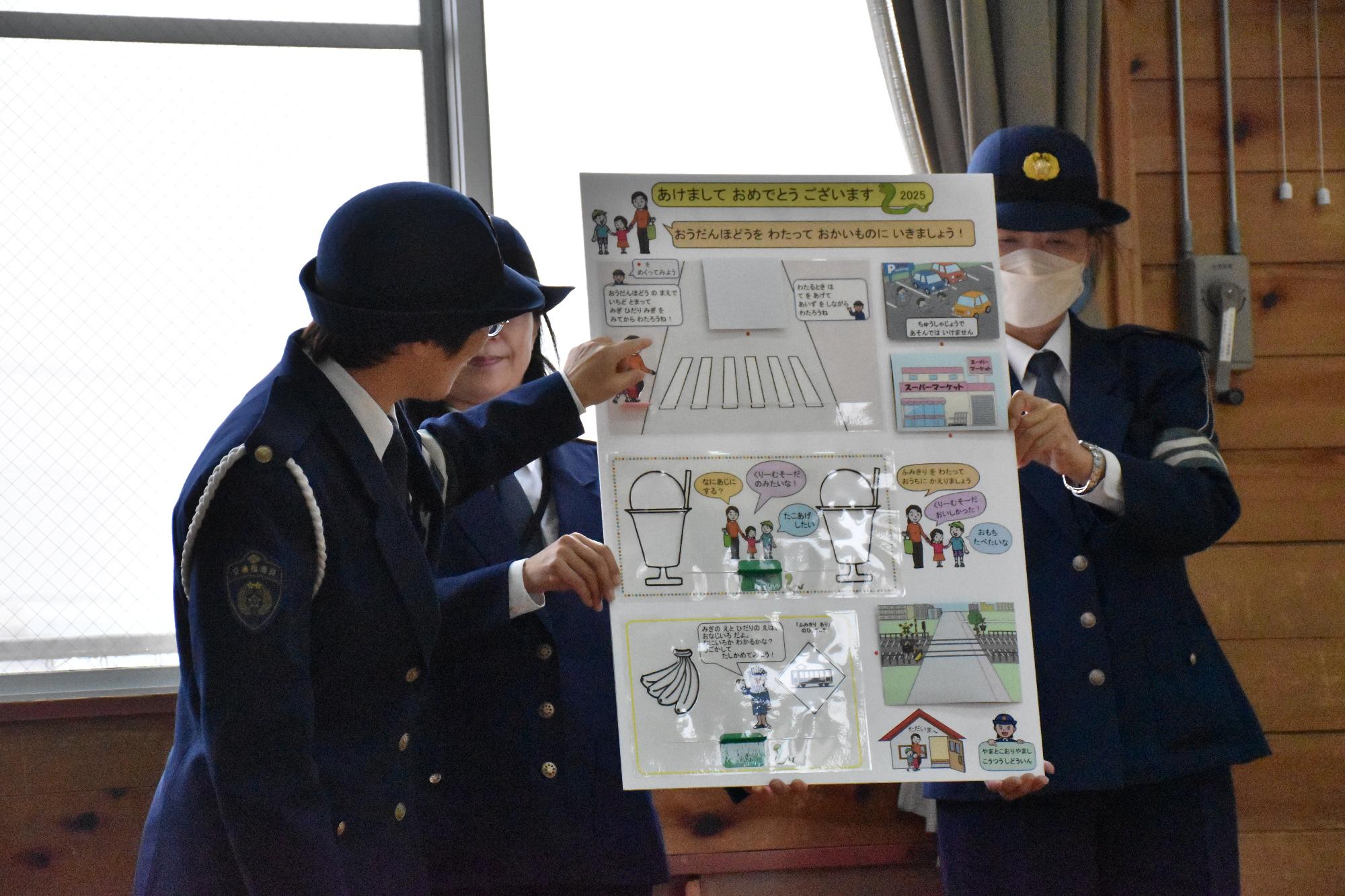 交通安全ジャンボ年賀状を園児に紹介している交通指導員