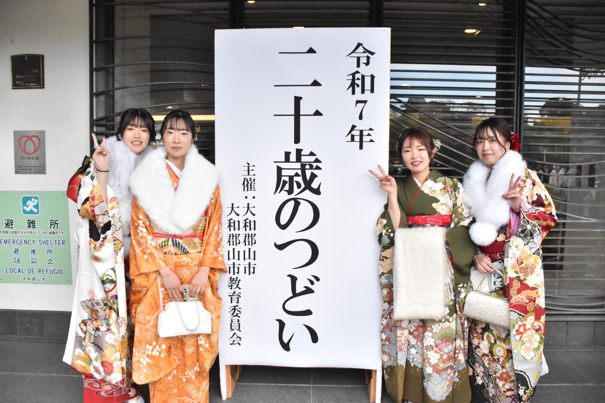 令和7年二十歳の集い 会場に集まった出席者 看板の前で記念撮影をする振り姿の女性
